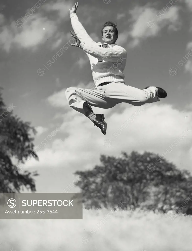 Vintage photograph. Man striking pose while jumping high in the air
