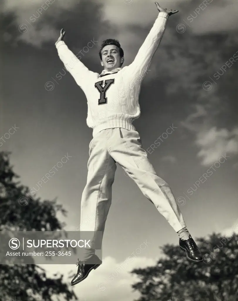 Low angle view of a male cheerleader jumping