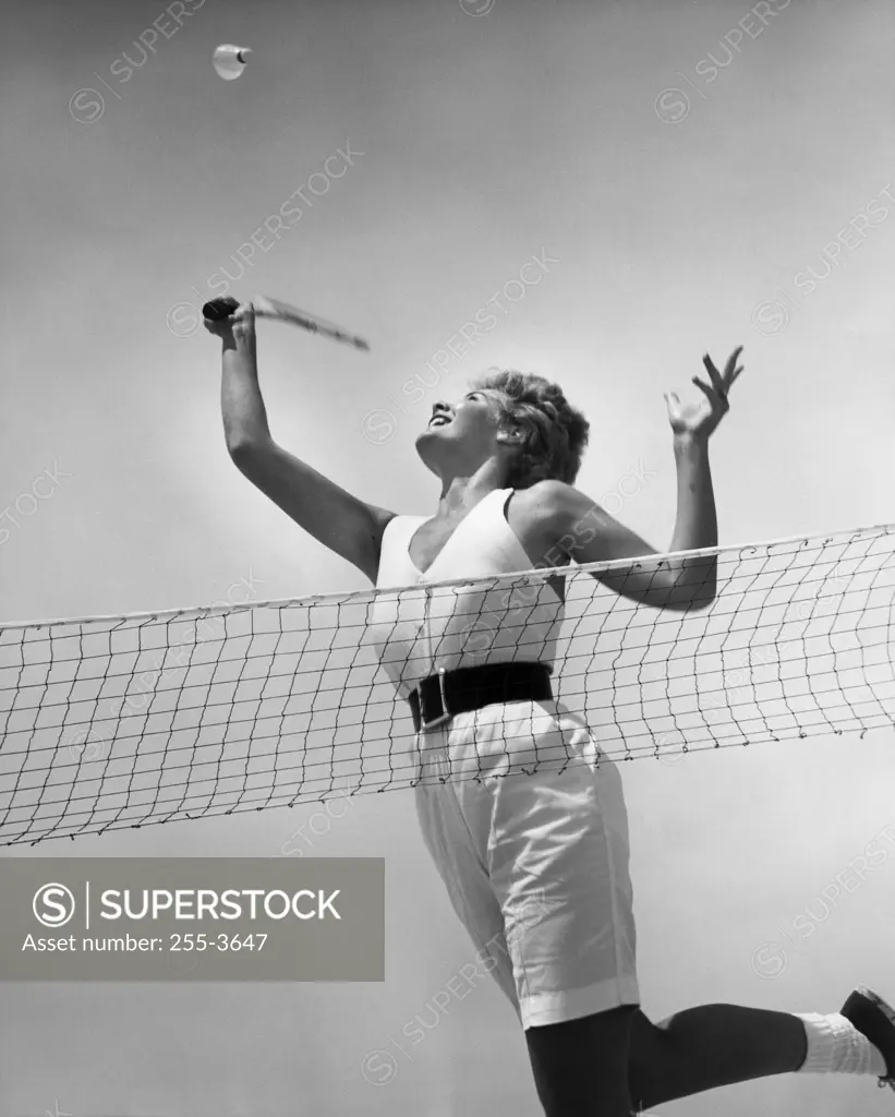 Low angle view of a young woman playing badminton