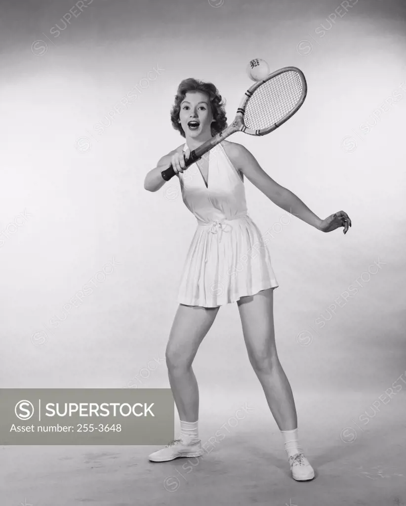 Young woman hitting a tennis ball with a tennis racket