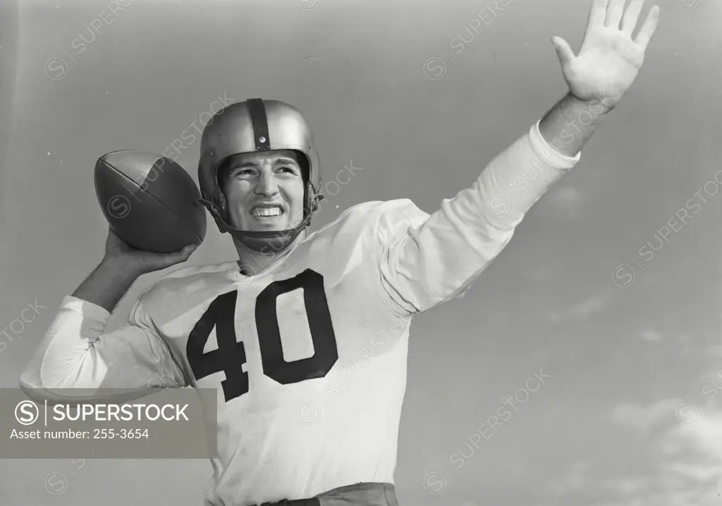 Vintage Photograph. Man in football pads throwing football