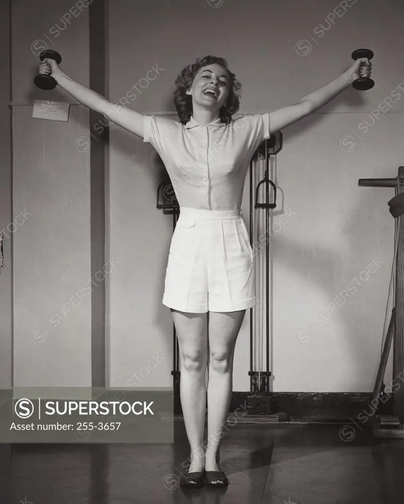 Young woman exercising in a gym and smiling
