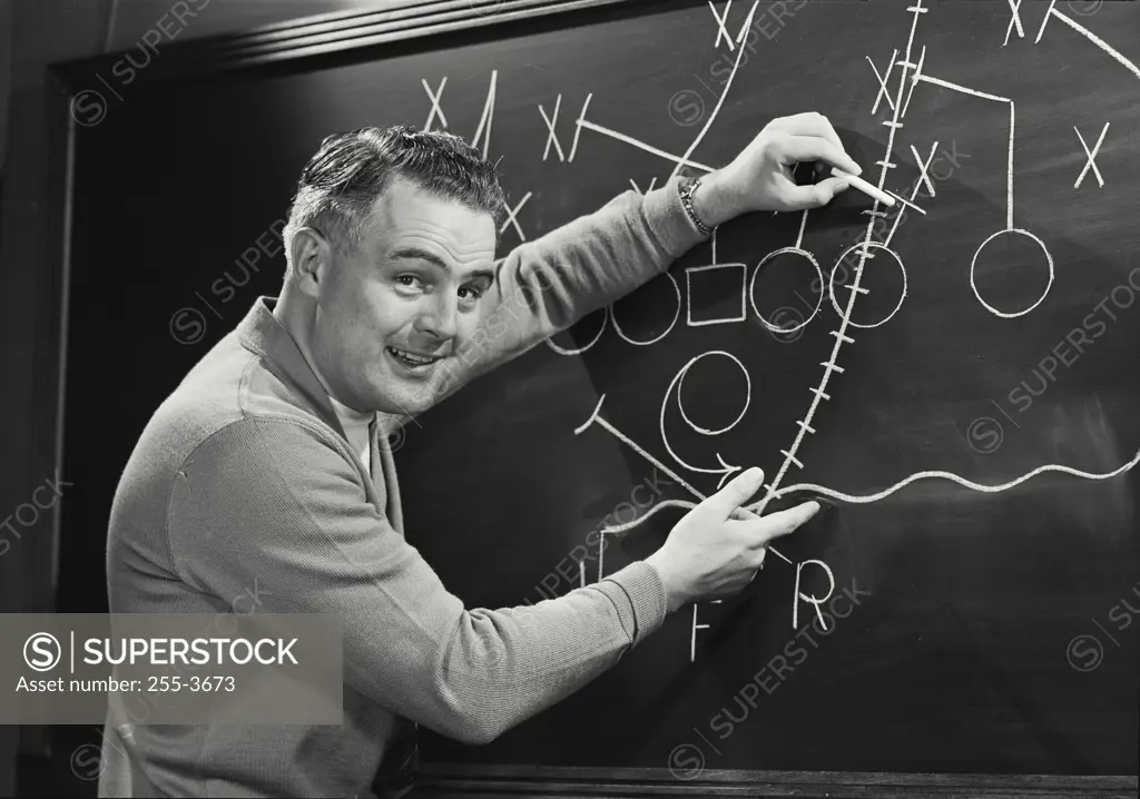 Vintage photograph. Picture of Football Coach in front of blackboard with plays.