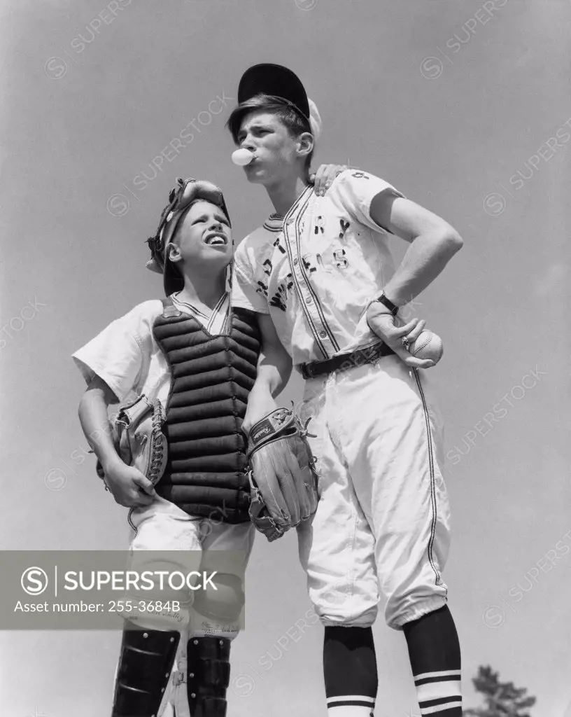 Low angle view of a youth league pitcher standing with a baseball catcher and planning