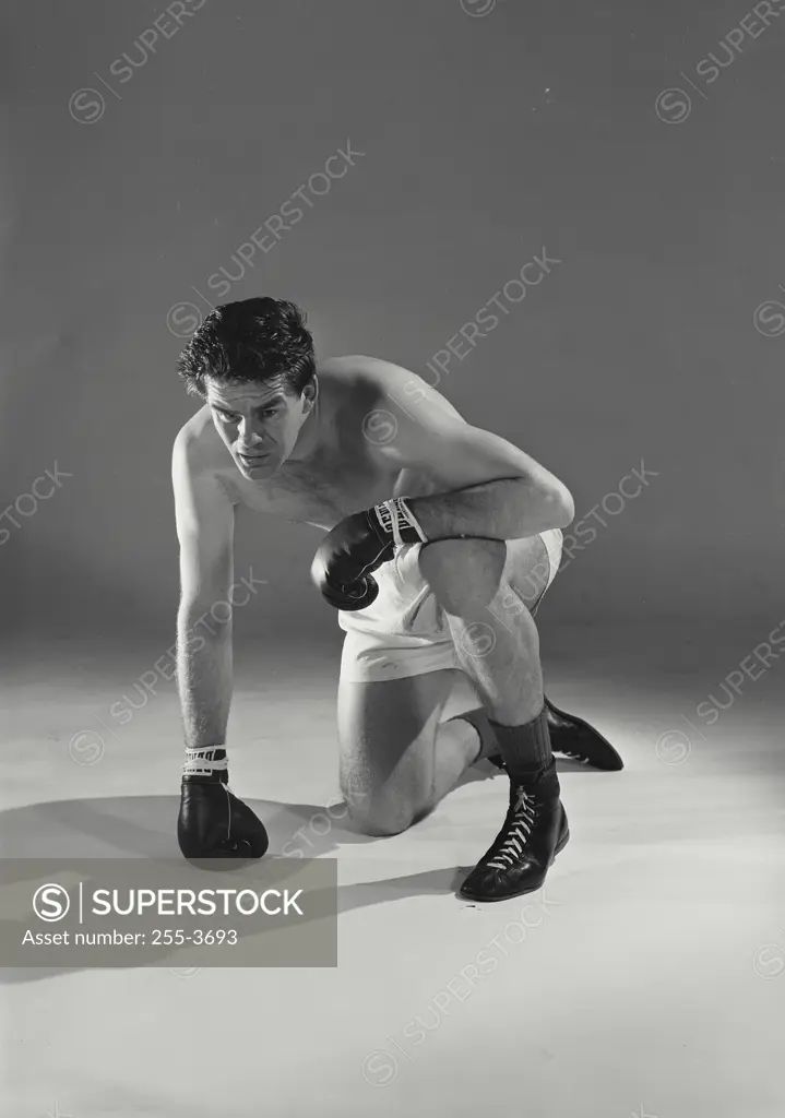 Vintage Photograph. Boxer kneeling and looking up after taking hit