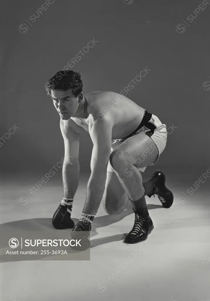 Vintage Photograph. Boxer kneeling on ground after taking hit