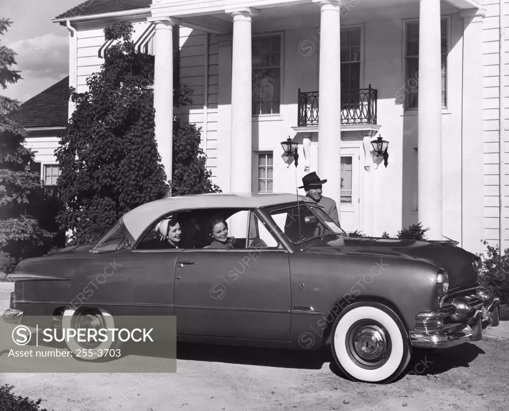 Car parked in front of a mansion, 1951 Ford Victoria