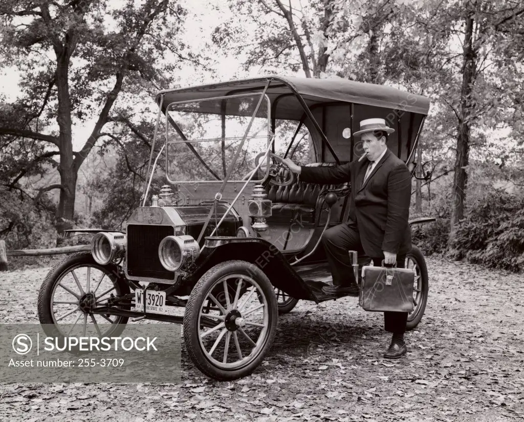Businessman standing beside Ford Model T, 1910