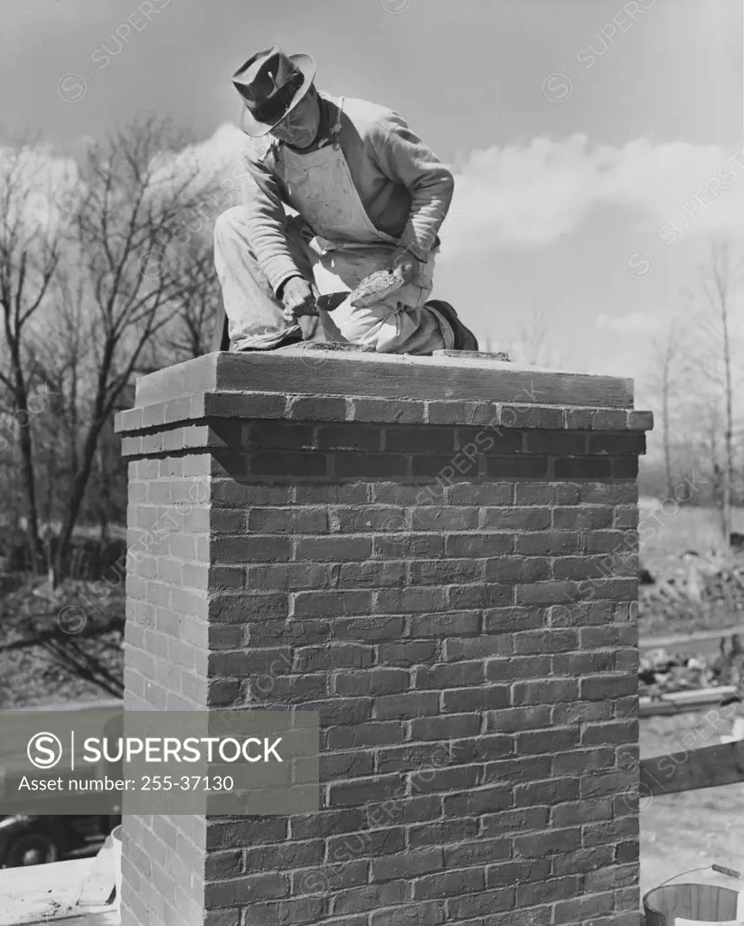 Low angle view of a man repairing a chimney