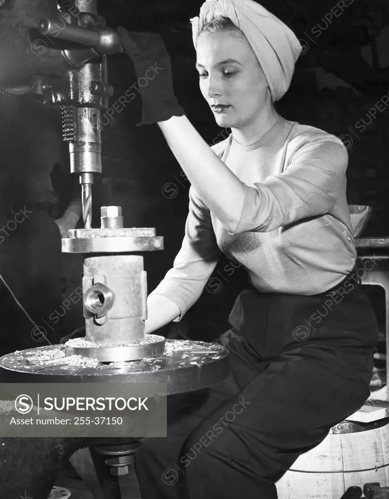 Female manual worker working on a milling machine