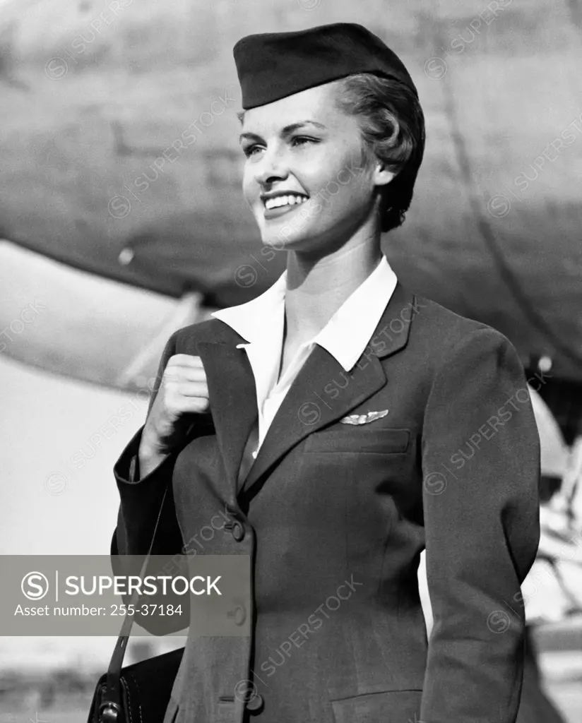 Air hostess carrying a bag and smiling