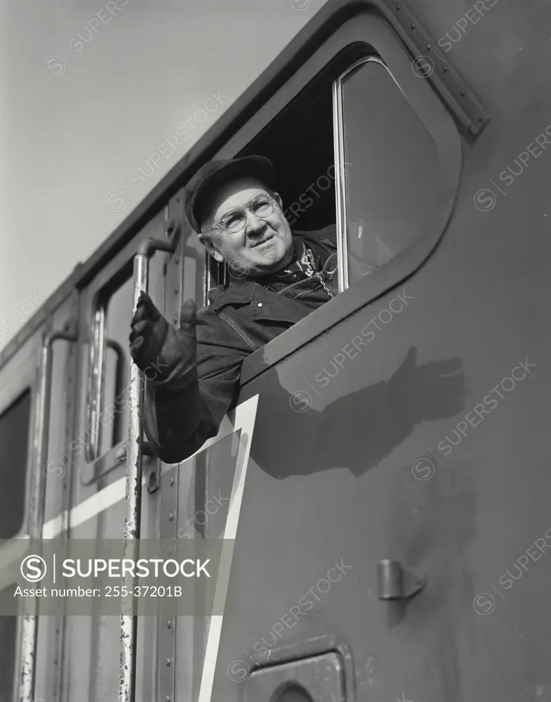 Vintage photograph. Engineer looking out of cab of a diesel locomotive waving
