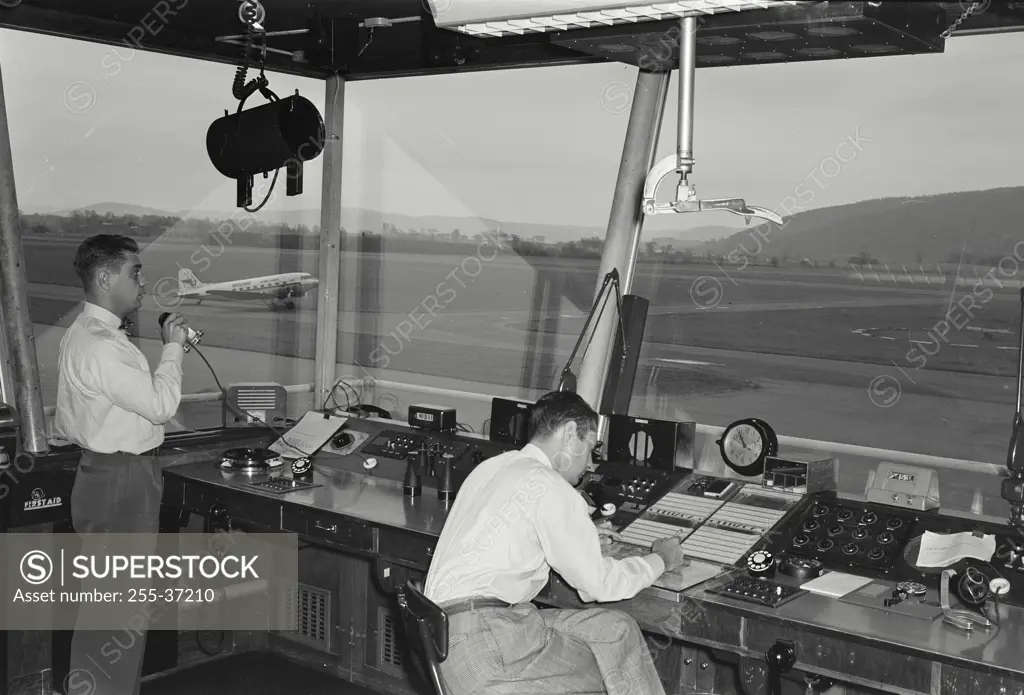Vintage Photograph. Two technicians working in an air traffic control tower, Elmira Airport, Elmira, New York State, USA