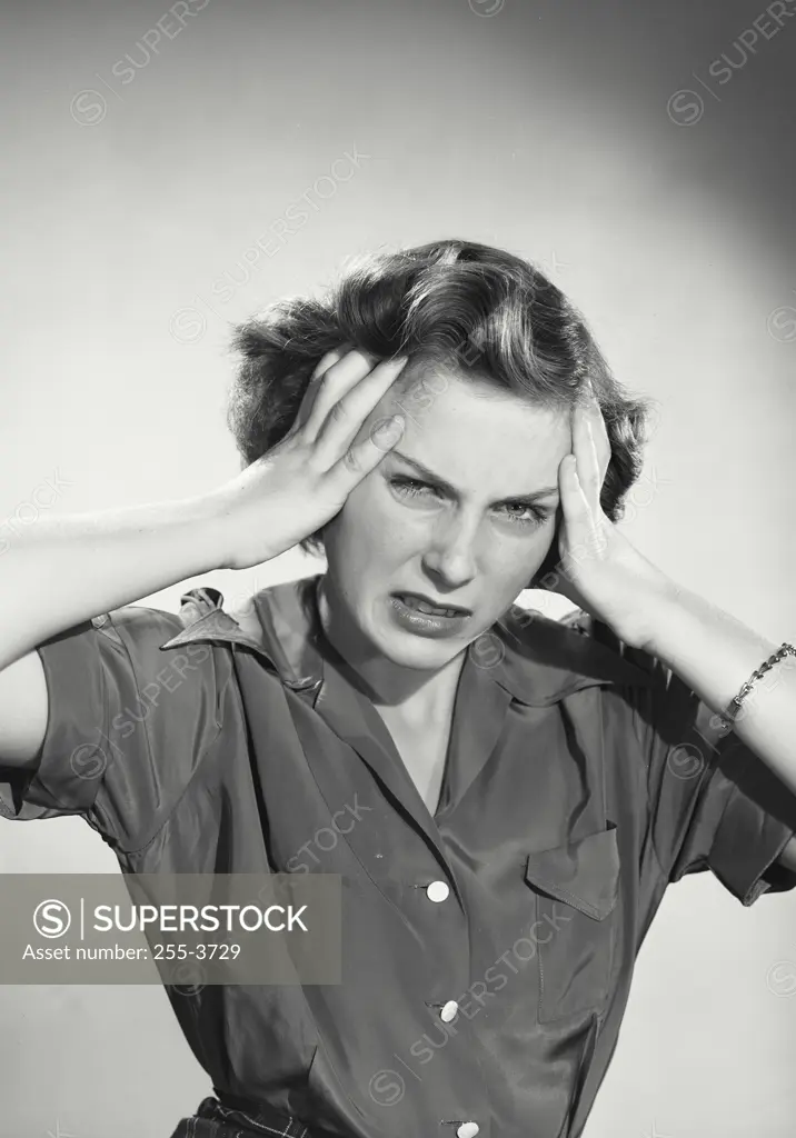 Vintage photograph. Woman holding hands up to head showing frustration