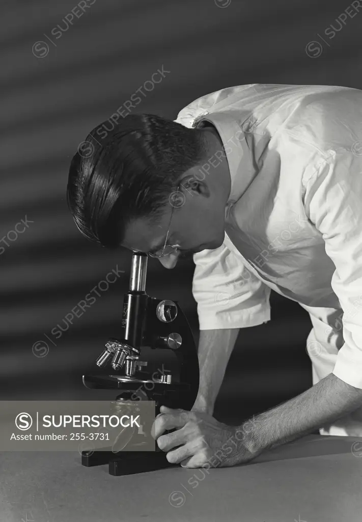 Vintage Photograph. Close-up of a scientist looking through a microscope