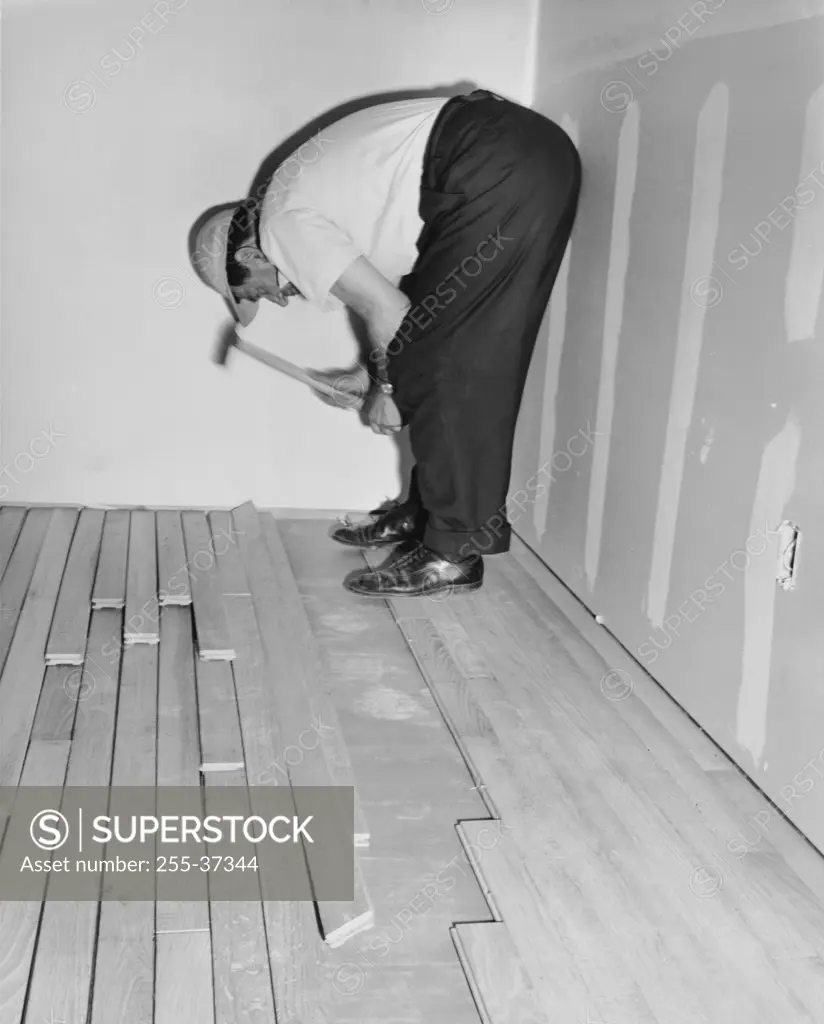 Side profile of a man laying a hardwood floor
