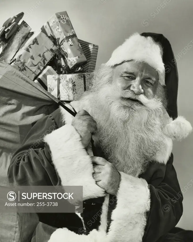 Portrait of Santa Claus carrying a sack of Christmas presents on his back