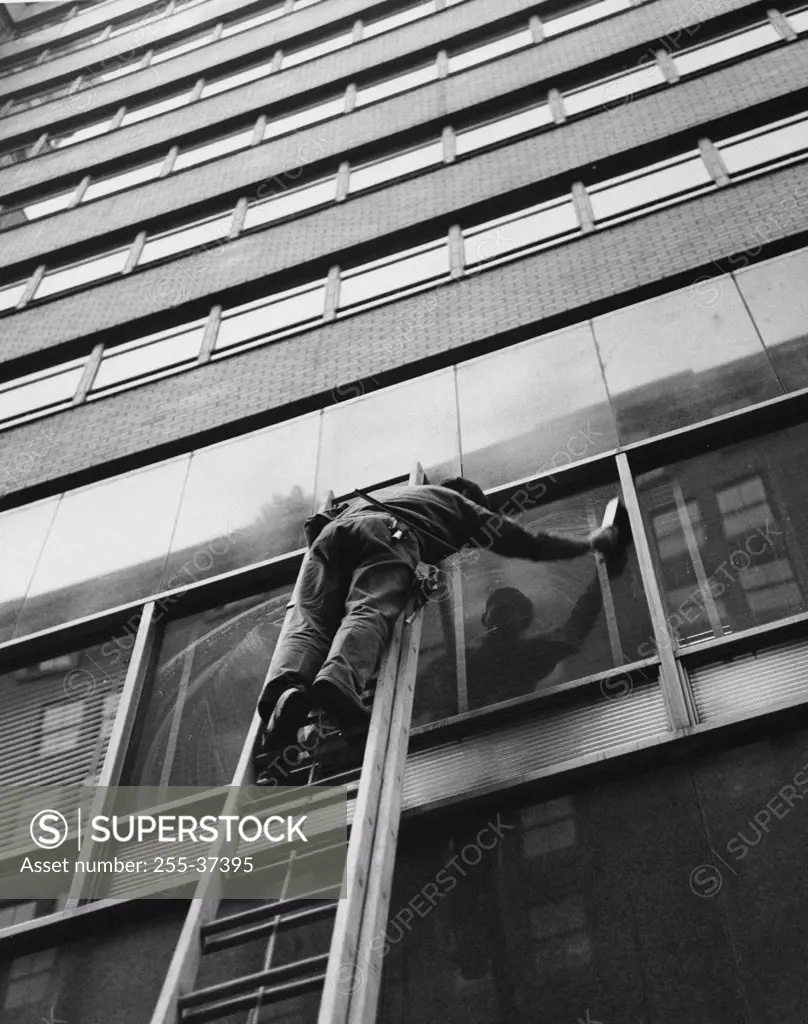 Low angle view of window washer cleaning window