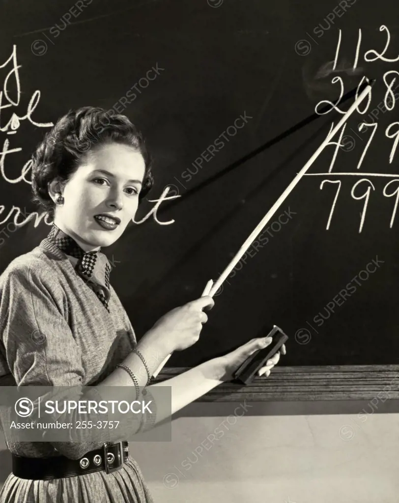 Side profile of a teacher pointing to a blackboard