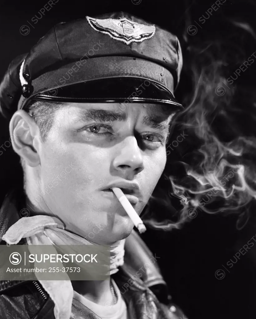 Studio portrait of young man smoking cigarette