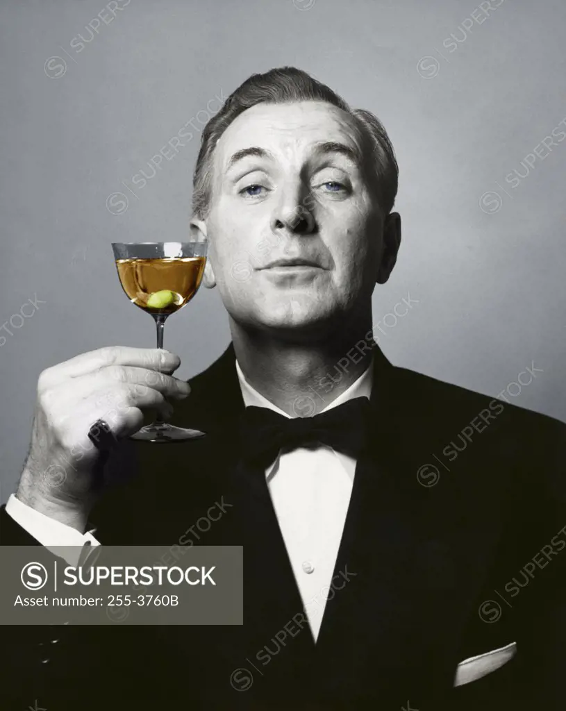 Portrait of a mature man holding a martini