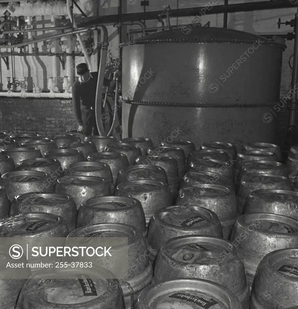 Vintage photograph. Man standing in room full of beer kegs at Ruppert Brewery, New York City