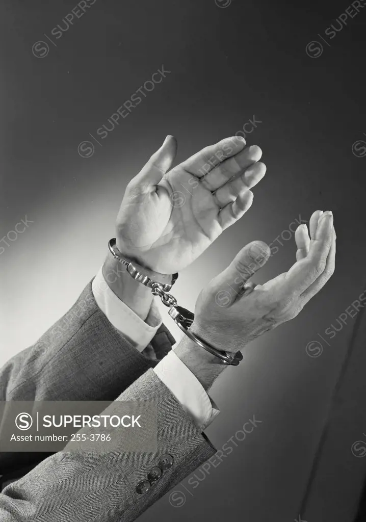 Vintage photograph. Close-up of man's hand wearing handcuffs