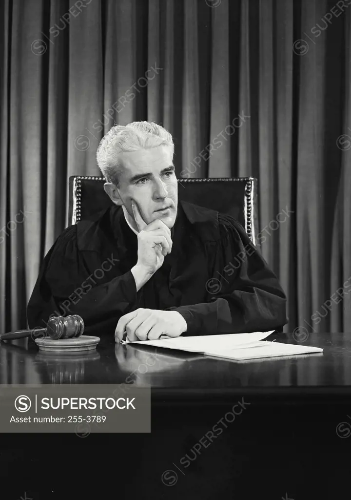 Vintage photograph. Close-up of a judge thinking with his hands on his chin