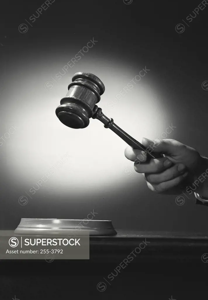 Vintage photograph. Close-up of a person's hand holding a gavel