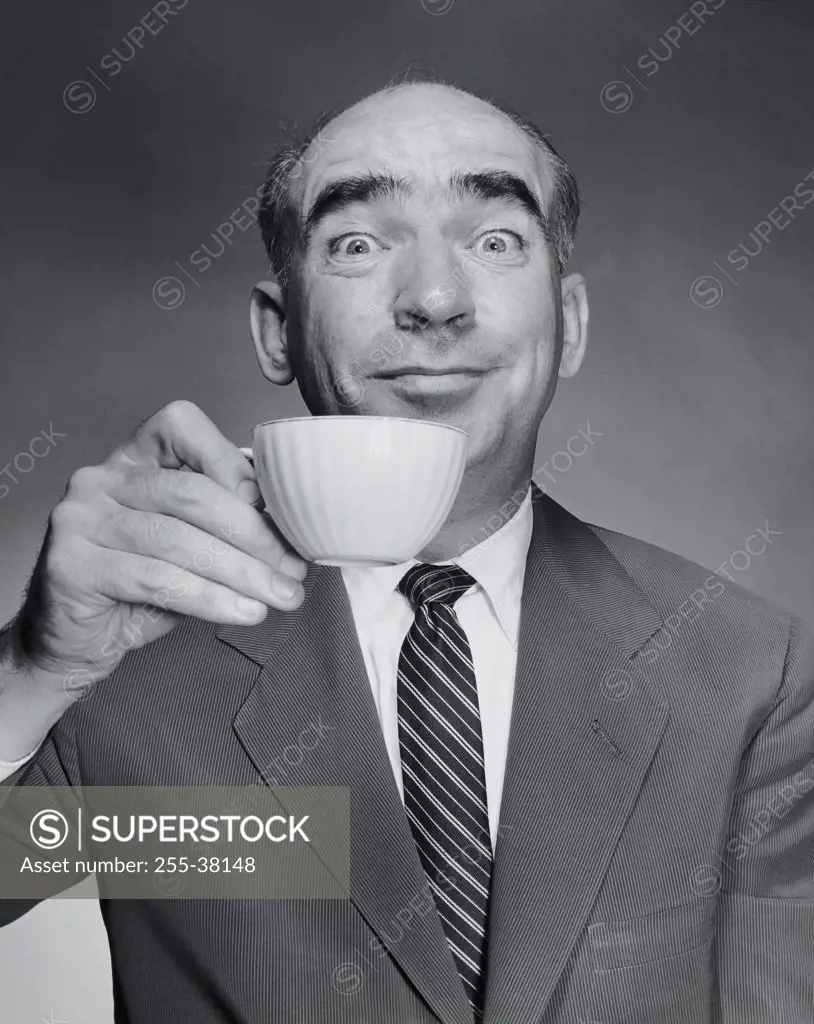 Studio portrait of mid adult man holding tea cup