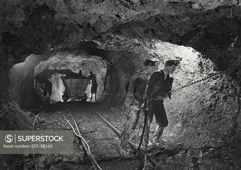 Vintage Photograph. Men in mine drilling bauxite ore, showing mine interior typical of such mining in Arkansas