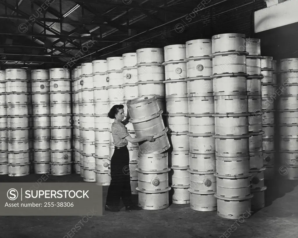 Vintage Photograph. Woman handling light weight aluminum drums