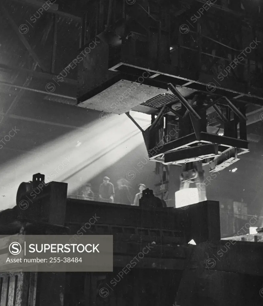 Vintage photograph. An ingot being lifted from a reheating furnace by a travelling crane at a British Steel factory