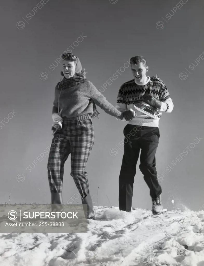 Low angle view of a young couple walking in snow