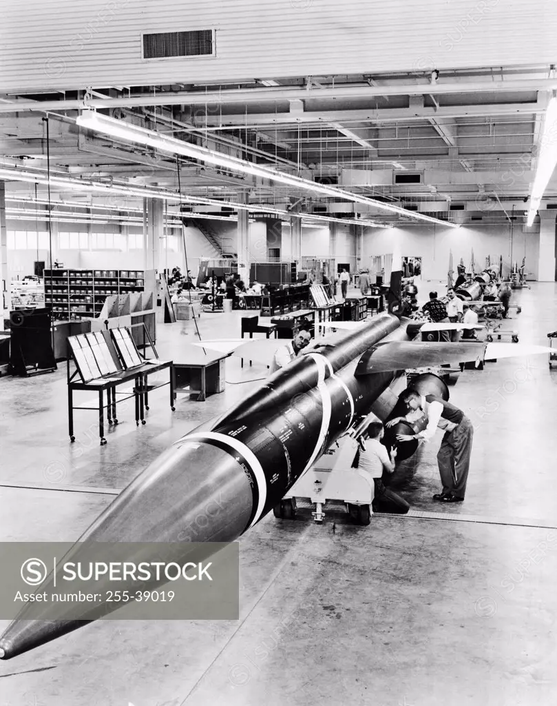 Engineers assembling aircrafts in a factory