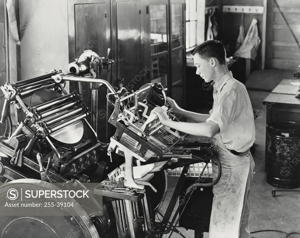 Vintage photograph. Young man learning printing trade which is part of the vocational training at Mooseheart, Illinois. Mooseheart is supported by the Supreme Lodge of the World Loyal Order of Moose
