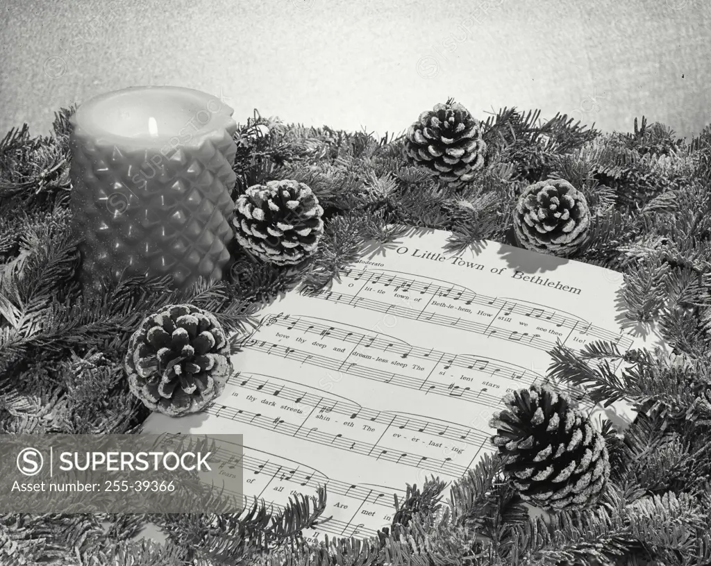 Vintage Photograph. Still life of pine cones and Christmas sheet music.