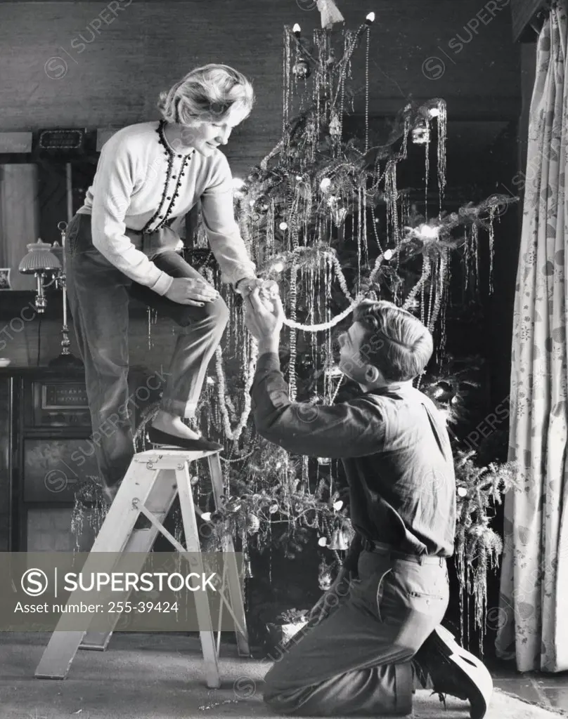 Young couple decorating a Christmas tree