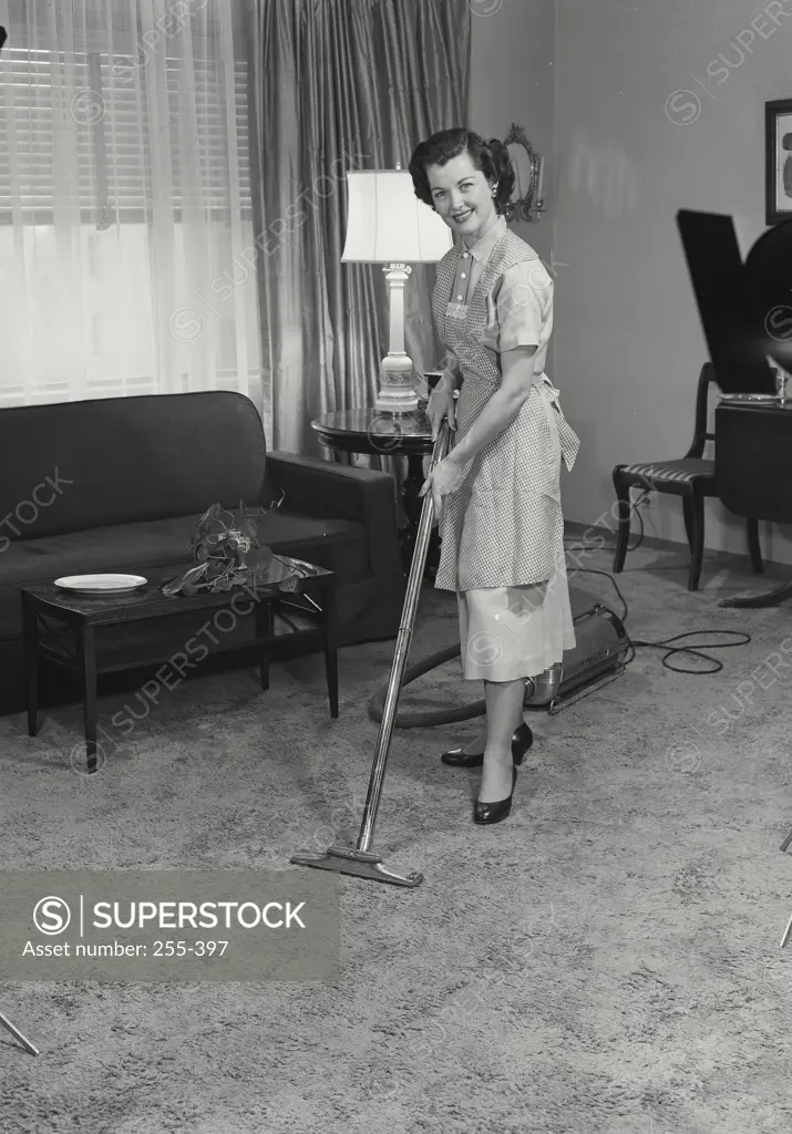 Vintage Photograph. Woman vacuuming the living room. Frame 2