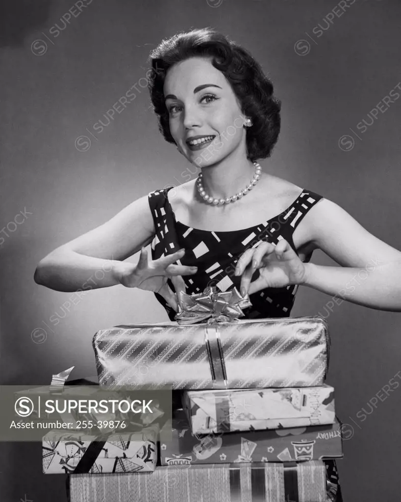 Portrait of a mid adult woman unwrapping Christmas presents and smiling