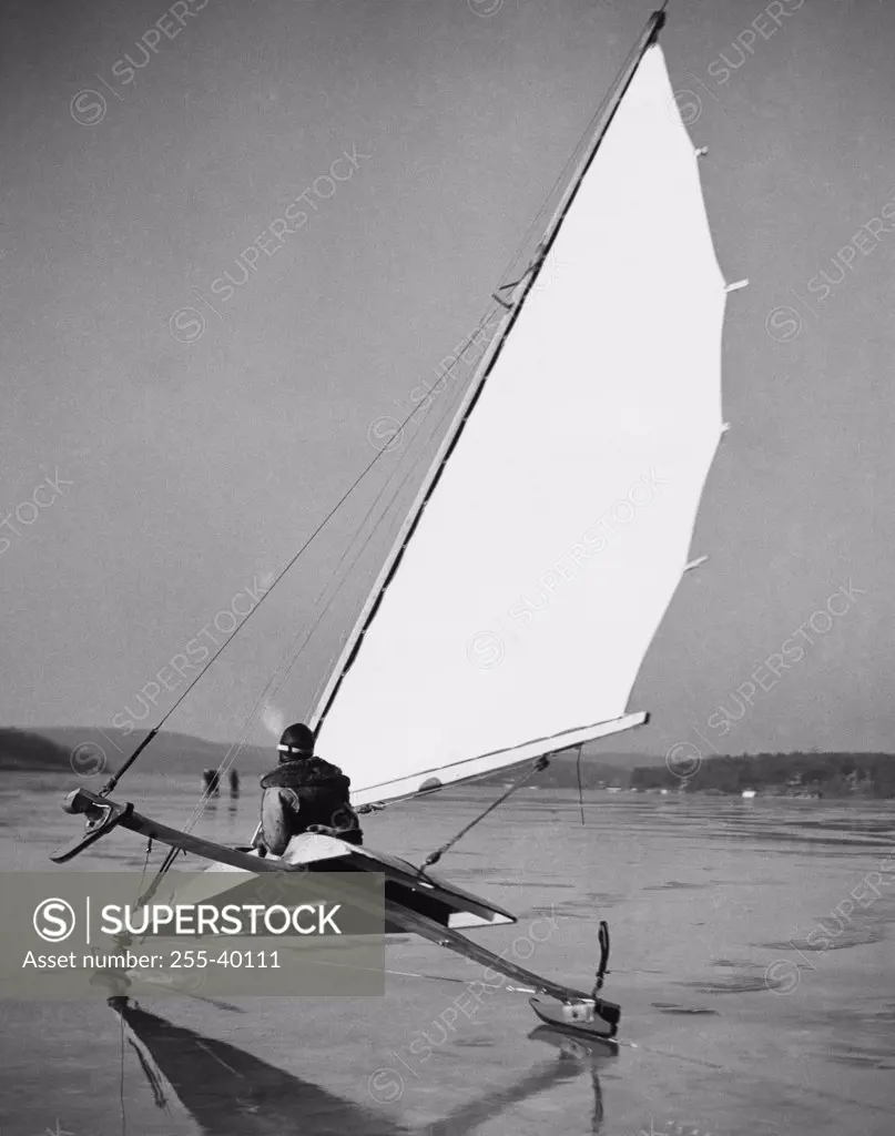Man sailing an ice boat on a frozen lake