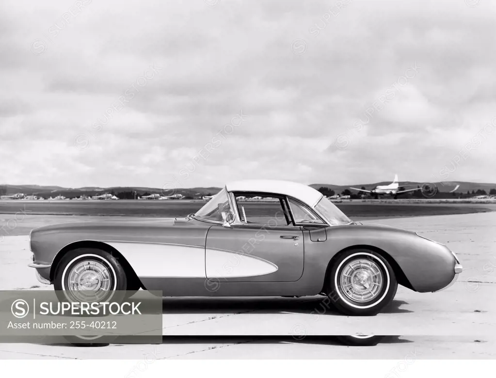 Side profile of a car parked in front of a runway, 1957 Chevrolet Corvette