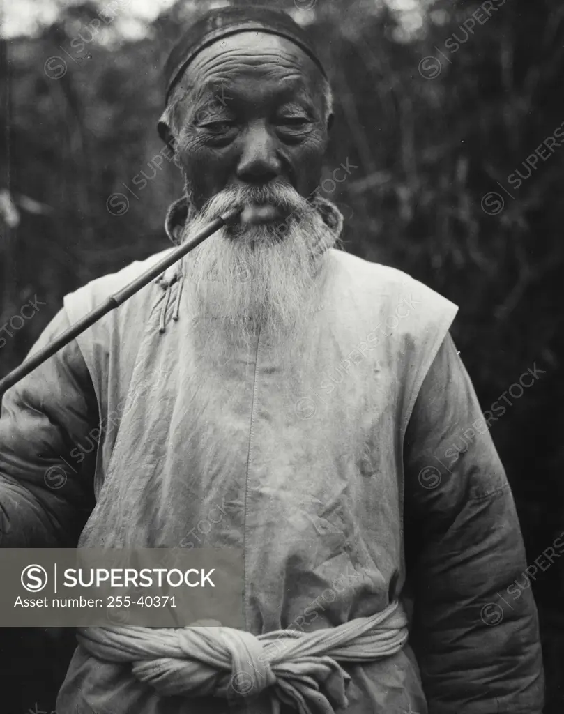 Vintage Photograph. Senior man smoking a pipe