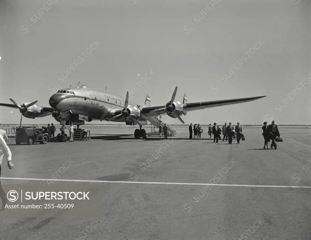 Vintage photograph. Passengers stepping off of Constellation onto tarmac