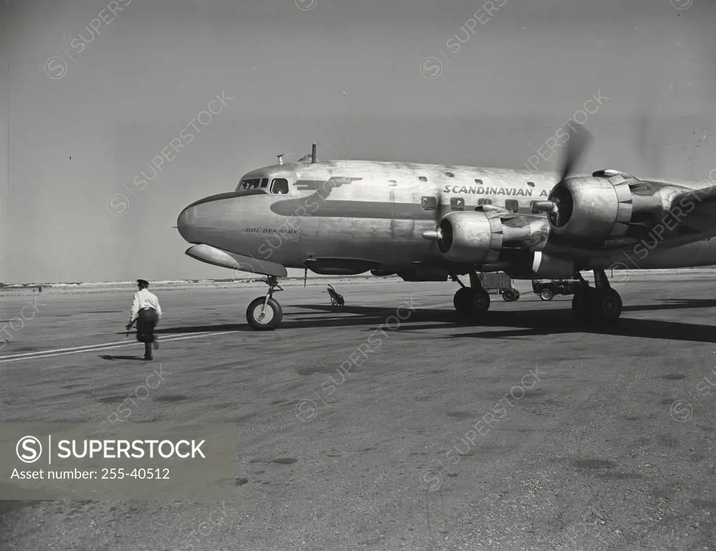 Vintage photograph. The ramp manager runs clear after checking out DC4 airliner of the Scandinavian airways