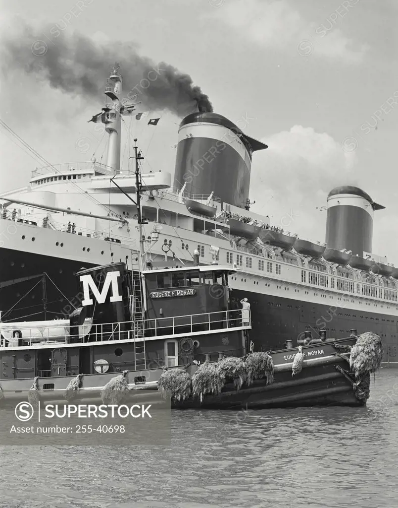 Vintage photograph. SS United States with Eugene F. Moran boat in foreground