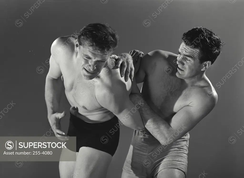 Vintage Photograph. Man twisting other mans arm behind back.