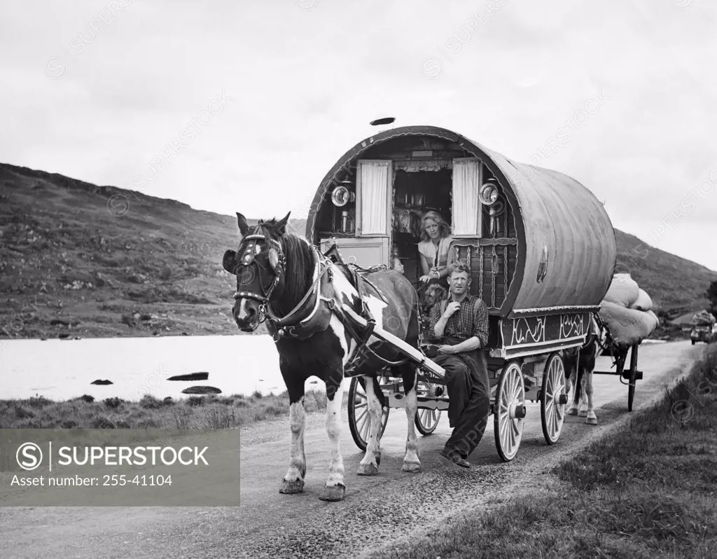 Young couple sitting on a covered wagon, Killarney, Ireland