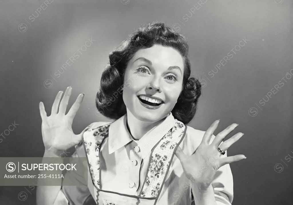 Vintage photograph. Portrait of young woman smiling with hands raised