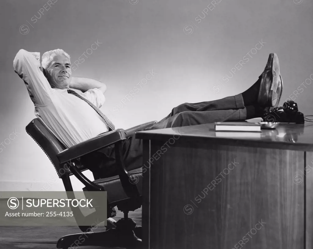 Businessman leaning in a chair with his feet resting on the desk